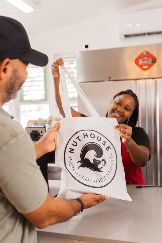 Nut House employee handing branded product bag to customer
